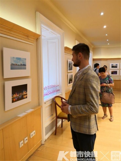 a visitor looks at the photos taken by hangzhou residents at a photo exhibition in budapest, capital of hungary, on aug 15.jpg